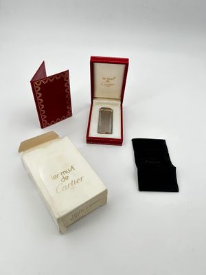 a small box with a watch inside of it on a white surface