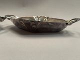 a close up of a metal bowl on a white surface