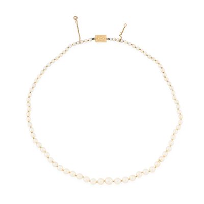 a white pearl necklace with a gold clasp on a white background