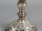 an image of a silver candle holder with a cross on it