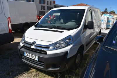 une camionnette blanche garée à côté d'autres voitures