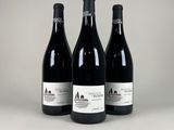 three bottles of wine sitting on top of a white table