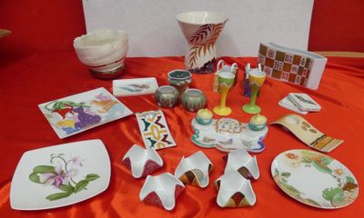 many plates and bowls on a table with a red table cloth