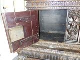 a wooden cabinet with a metal door open on the floor