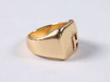 an image of a gold signet ring on a white surface
