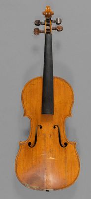 an old violin with a bow hanging on a wall
