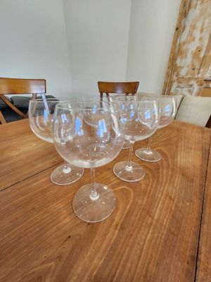 several empty wine glasses sitting on a wooden table in a room