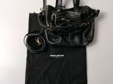 a black purse and a black bag on a white table
