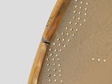a close up of a round mirror with holes in it