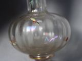 a glass vase with a dragonfly in it on a table