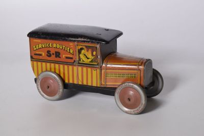 un petit camion jouet posé sur une surface blanche