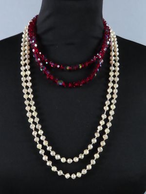 un gros plan sur un mannequin portant un collier de perles rouges et blanches