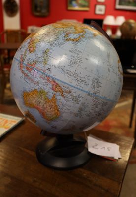 a globe on a table in a room with a red wall