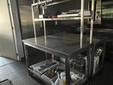 une cuisine avec un plan de travail en inox et une étagère en métal
