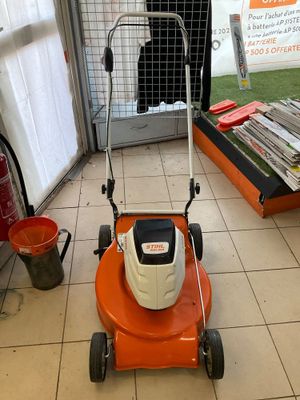 a lawn mower that is sitting on the floor in a room