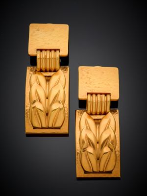 une paire de boucles d'oreilles en bois sculpté ornées de fleurs et de feuilles