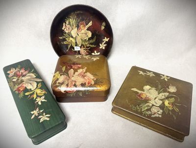 trois boîtes ornées de fleurs, posées sur une table