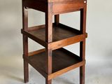 une petite table en bois sur laquelle sont posées trois étagères