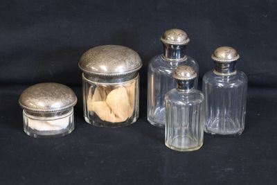 trois bocaux en verre avec des couvercles argentés et une boîte à biscuits