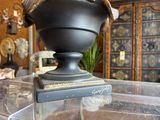 a vase with a hat on top of it sitting on a table