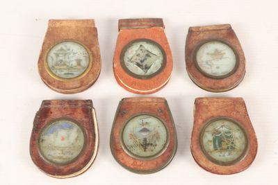 six wooden toilet seats with pictures on them on a white surface