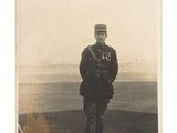 une vieille photo d'un homme en uniforme debout dans un champ
