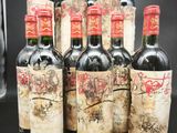 six bouteilles de vin sont alignées sur une table