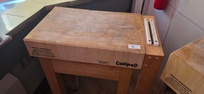 a wooden table with a knife on it in a kitchen