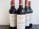 six bottles of red wine are lined up on a table