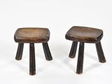 une paire de petits tabourets en bois aux pieds courbés, sur fond blanc