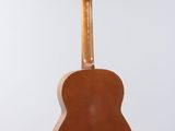 a close up of a guitar hanging from a string on a wall