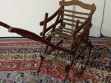 une petite chaise en bois posée sur un tapis posé à même le sol