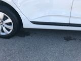 a close up of a white car parked on the side of the road