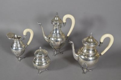 four pieces of silver tea and coffee set on a grey background