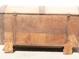 a wooden chest sitting on the ground with a white wall in the background