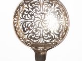 a silver spoon with a flower design on it