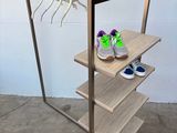 porte-vêtements en bois avec trois étagères et une paire de chaussures