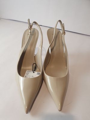 une paire de chaussures pour femme posée sur une surface blanche, avec un fond blanc