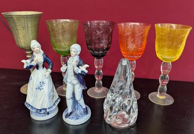 sept verres en verre de couleurs différentes posés sur une table