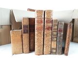 several old books are stacked on top of each other on a table