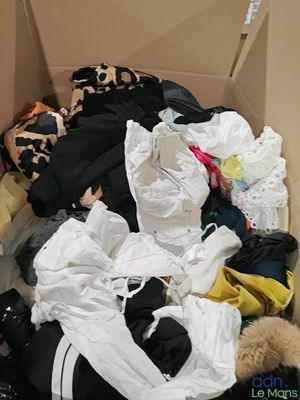 une boîte remplie de vêtements, avec un ours en peluche à l'intérieur