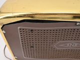 a close up of a gold toaster on a white table