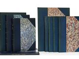 plusieurs livres sont alignés sur une surface blanche