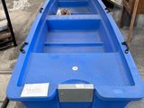 un bateau bleu vide posé sur le sol d'un entrepôt