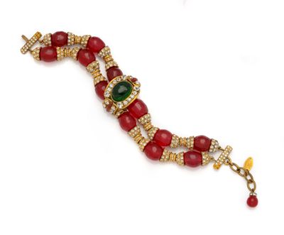 a close up of a red and green bracelet on a white surface