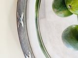 three limes in a glass bowl on a table