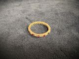 a close up of a gold ring with red stones on a black surface