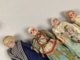 five dolls that are lined up on a white surface