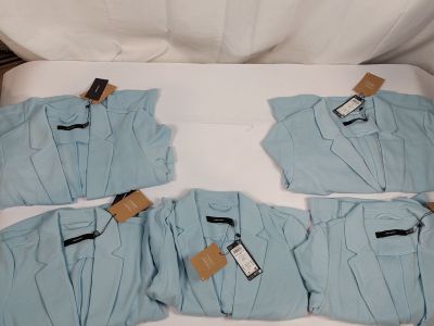 quatre paires de pyjamas bleus pour homme posées sur un lit blanc