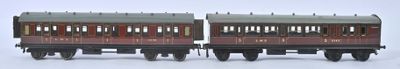 two miniature trains sitting side by side on a white surface